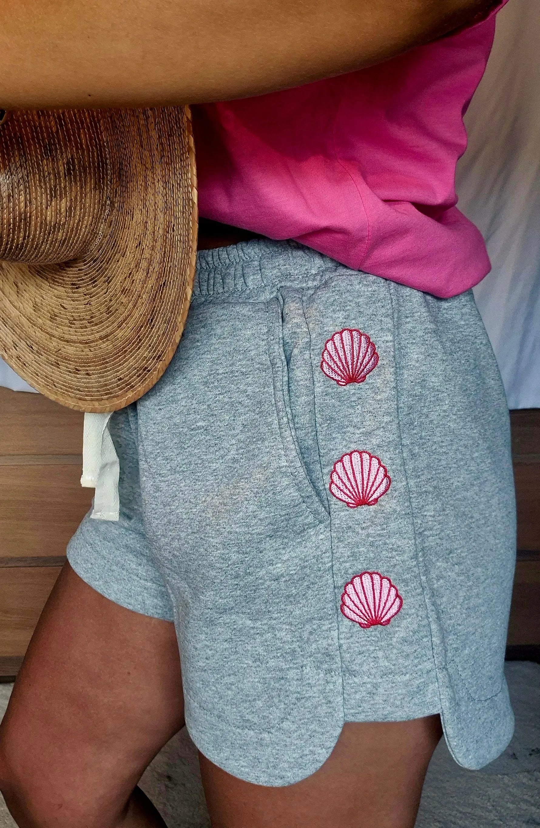 Gros plan sur les broderies coquillages roses du short Candice gris.
