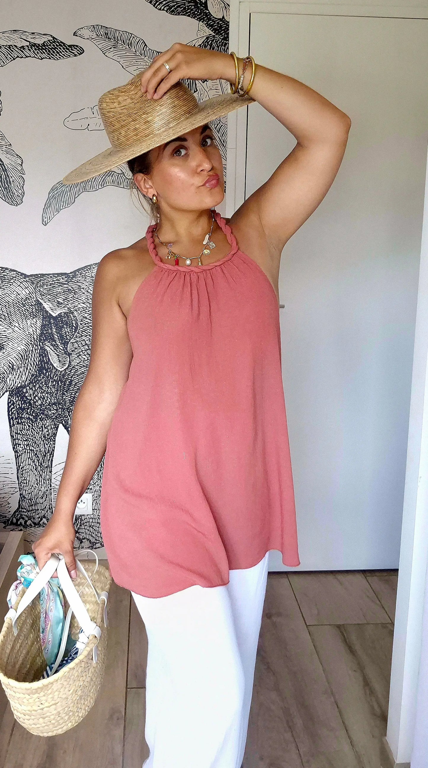 Top Sienna de face avec pantalon blanc un sac en osier et chapeau en paille